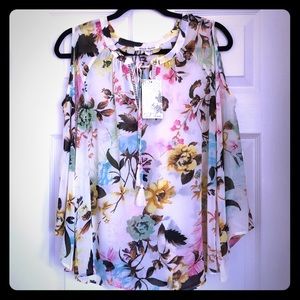 Flower covered cold shoulder see-through blouse.